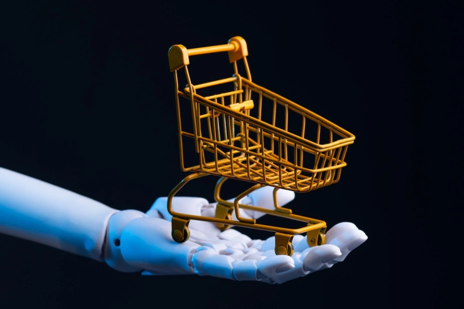 ręka robota i miniaturowy kosz zakupowy