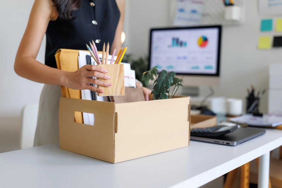 pracownik z kartonem na biurku