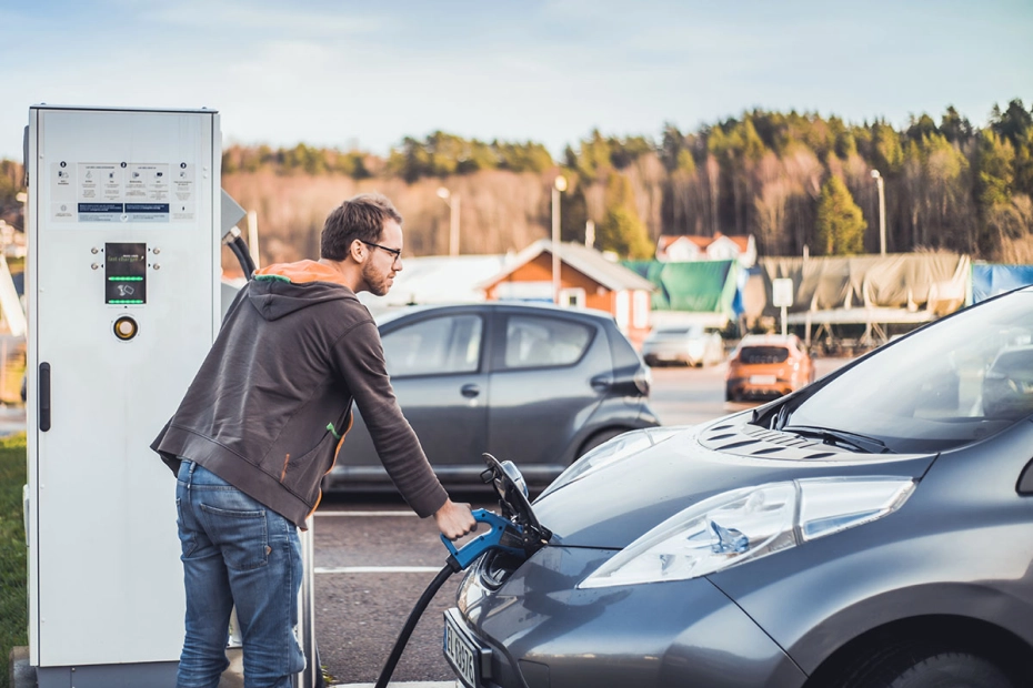 mężczyzna ładuje samochód elektryczny